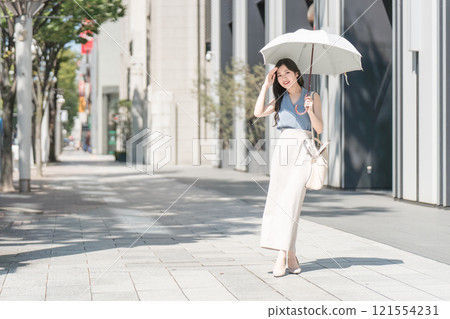 在辦公區拿著遮陽傘的女商人 在辦公區拿著遮陽傘的女商人 121554231