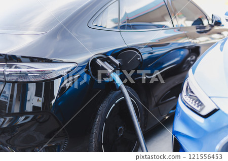 Electric car at charging station with the power cable supply plugged. 121556453