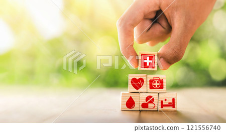 Hand arranged wooden blocks with icons of medical health. health insurance for your health concept. Healthcare medical business, medical technology equipment icon. 121556740