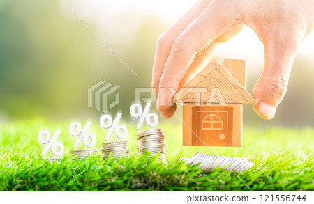 House placed on coins Men's hand is planning savings money of coins to buy a home concept concept for property ladder, mortgage and real estate investment. House placed on coins Men's hand is planning savings money of coins to buy a home concept concept for property ladder, mortgage and real estate investment. 121556744