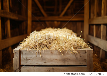 A wooden box full of hay stands in the barn 121557012