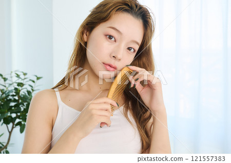 一個女人用梳子梳理頭髮 121557383