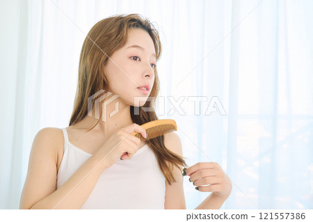 Woman combing her hair with a comb 121557386