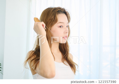 一個女人用梳子梳理頭髮 121557390