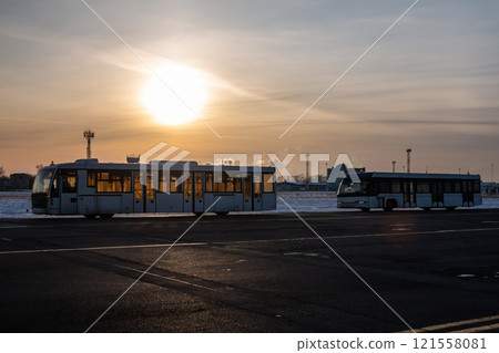 Two empty airport shuttle buses in a cold winter evening 121558081