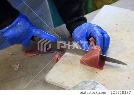 Raw tuna being cut into pieces Raw tuna being cut into pieces 121558387