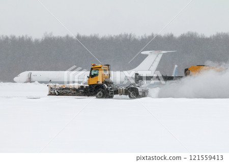 Airfield snow blower cleaning the runway at the airport in a severe blizzard Airfield snow blower cleaning the runway at the airport in a severe blizzard 121559413
