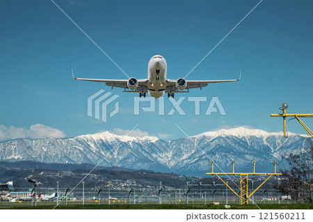 Takeoff of a white passenger aircraft against the backdrop of high picturesque mountains Takeoff of a white passenger aircraft against the backdrop of high picturesque mountains 121560211