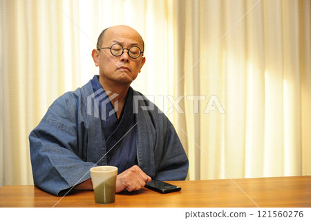 穿著日式服裝放鬆的中年男子 穿著日式服裝放鬆的中年男子 121560276