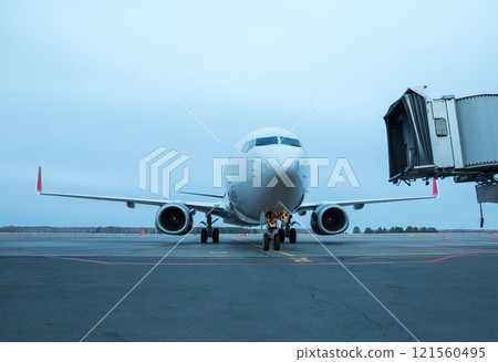 Passenger airliner taxiing to the boarding bridge 121560495