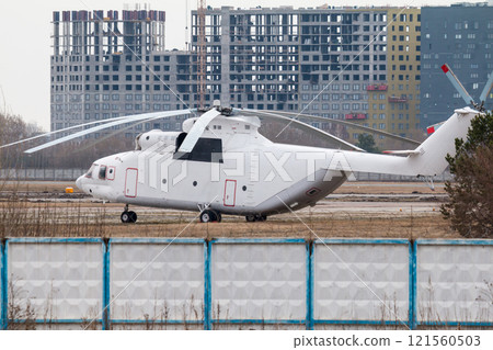 Large white cargo helicopter at the landing site surrounded by buildings under construction Large white cargo helicopter at the landing site surrounded by buildings under construction 121560503