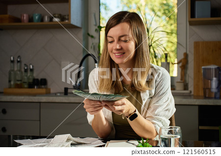 Happy woman counting dollar banknotes at home. Budget planning Happy woman counting dollar banknotes at home. Budget planning 121560515