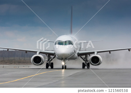 Close-up a passenger aircraft taxiing through a water salute in honor of the first visit Close-up a passenger aircraft taxiing through a water salute in honor of the first visit 121560538