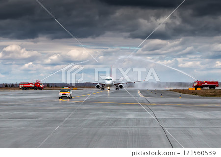 Water salute by fire truck at the airport for first visit passenger airplane Water salute by fire truck at the airport for first visit passenger airplane 121560539