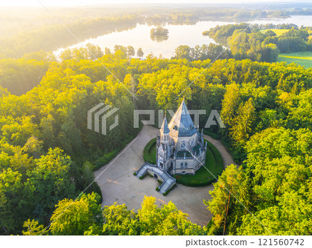 The Schwarzenberg Tomb stands majestically amidst a vibrant green forest in Domanin, Czechia. The serene setting enhances the tomb gothic architecture against a backdrop of tranquil waters. The Schwarzenberg Tomb stands majestically amidst a vibrant green forest in Domanin, Czechia. The serene setting enhances the tomb gothic architecture against a backdrop of tranquil waters. 121560742