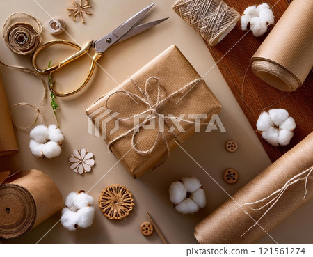 A beautifully wrapped gift with brown paper and cotton balls around it on the table 121561274