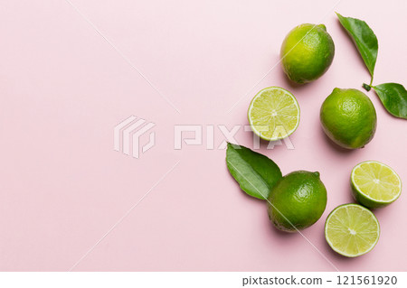 Lime fruits with green leaf and cut in half slice isolated on white background. Top view. Flat lay with copy space 121561920