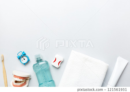 Mouthwash and other oral hygiene products on colored table top view with copy space. Flat lay. Dental hygiene. Oral care products and space for text on light background. concept Mouthwash and other oral hygiene products on colored table top view with copy space. Flat lay. Dental hygiene. Oral care products and space for text on light background. concept 121561931