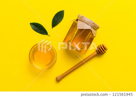 Honey jar with wooden honey dipper on white background top view with copy space. Delicious honey bottle 121561945