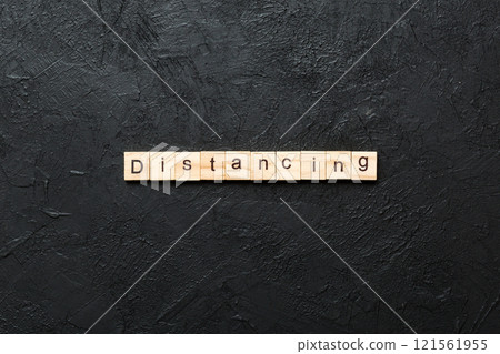 distancing word written on wood block. distancing text on cement table for your desing, concept 121561955