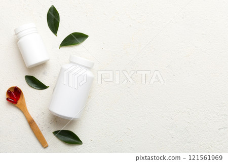 different drugs and health supplement pills with medicine bottle health care and medical top view. Vitamin tablets. Bottle with colored pills on table background. Multivitamins 121561969