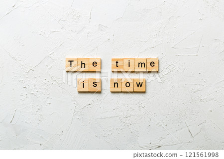 the time is now word written on wood block. the time is now text on table, concept 121561998