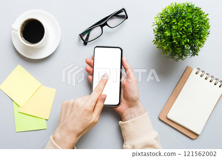 Top view of woman hands holding smart phone with blank copy space screen for your text message or information content. woman hand using phone white screen on top view Top view of woman hands holding smart phone with blank copy space screen for your text message or information content. woman hand using phone white screen on top view 121562002