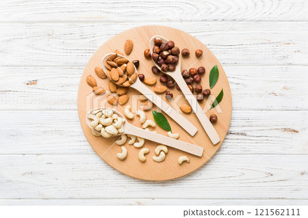 Assortment of nuts in wooden spoon on colored table. Cashew, hazelnuts, walnuts, almonds. Mix of nuts Top view with copy space Assortment of nuts in wooden spoon on colored table. Cashew, hazelnuts, walnuts, almonds. Mix of nuts Top view with copy space 121562111