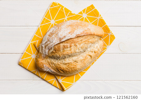 Freshly baked delicious french bread with napkin on rustic table top view. Healthy white bread loaf 121562160