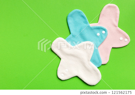 Eco-friendly reusable fabric women's pads. set of colorful bright reusable menstrual pads. zero waste woman periods concept top view with copy space Eco-friendly reusable fabric women's pads. set of colorful bright reusable menstrual pads. zero waste woman periods concept top view with copy space 121562175