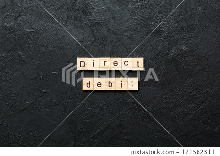 direct debit word written on wood block. direct debit text on cement table for your desing, concept 121562311