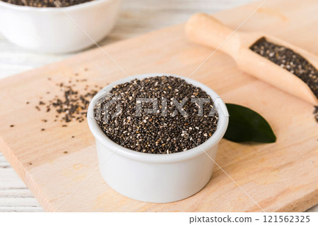 Chia seeds in bowl and spoon on colored background. Healthy Salvia hispanica in small bowl. Healthy superfood 121562325