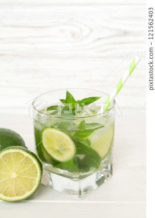 Mojito cocktail. Refreshing mojito cocktail with lime, lemon and mint in a tall glass with a stick 121562403