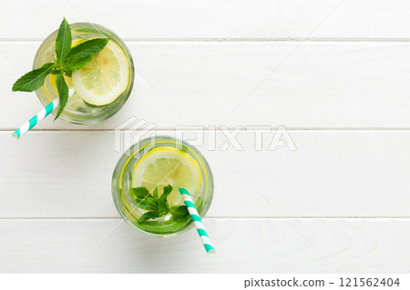 Caipirinha, Mojito cocktail, vodka or soda drink with lime, mint and straw on table background. Refreshing beverage with mint and lime in glass top view flat lay 121562404