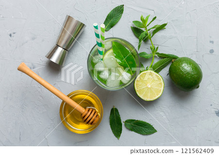 Caipirinha, Mojito cocktail, vodka or soda drink with lime, mint and straw on table background. Refreshing beverage with mint and lime in glass top view flat lay 121562409