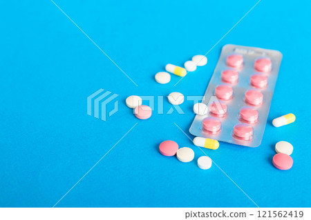 Blister package with Vitamin on color background. Medicine pills on a light background. Medicines and prescription pills flat lay background. pink medical tablets in blister Blister package with Vitamin on color background. Medicine pills on a light background. Medicines and prescription pills flat lay background. pink medical tablets in blister 121562419