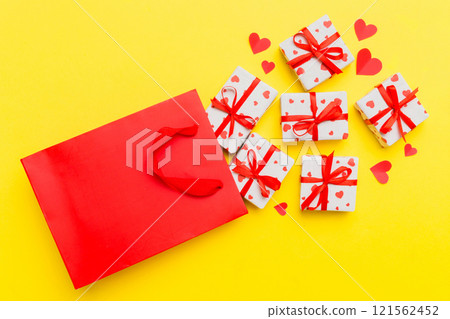 Gift boxes pop out from paper bag top view on colored background. bag packing handmade boxes fall out Concept of holidays, shopping, sale, discounts. Top view, flat lay Gift boxes pop out from paper bag top view on colored background. bag packing handmade boxes fall out Concept of holidays, shopping, sale, discounts. Top view, flat lay 121562452