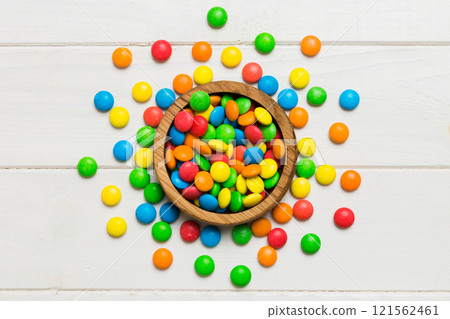 Multicolored candies in a bowl on a colored background. birthday and holiday concept. Top view with copy space 121562461