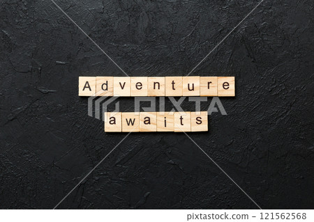 Adventure awaits word written on wood block. Adventure awaits text on cement table for your desing, concept Adventure awaits word written on wood block. Adventure awaits text on cement table for your desing, concept 121562568