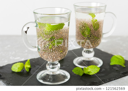 Healthy breakfast or morning with chia seeds and mint on table background, vegetarian food, diet and health concept. Chia pudding with and mint Healthy breakfast or morning with chia seeds and mint on table background, vegetarian food, diet and health concept. Chia pudding with and mint 121562569