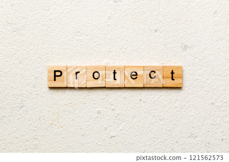 PROTECT word written on wood block. PROTECT text on cement table for your desing, concept 121562573