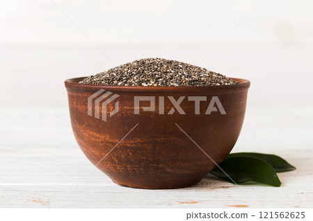 Chia seeds in bowl on colored background. Healthy Salvia hispanica in small bowl. Healthy superfood Chia seeds in bowl on colored background. Healthy Salvia hispanica in small bowl. Healthy superfood 121562625