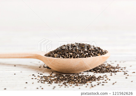 Wooden spoon and chia seeds on colored background, top view. Healthy Salvia hispanica Healthy superfood Wooden spoon and chia seeds on colored background, top view. Healthy Salvia hispanica Healthy superfood 121562626
