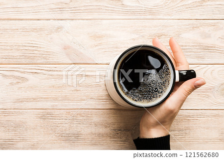 Minimalistic style woman hand holding a cup of coffee on Colored background. Flat lay, top view cappuccino cup. Empty place for text, copy space. Coffee addiction. Top view, flat lay Minimalistic style woman hand holding a cup of coffee on Colored background. Flat lay, top view cappuccino cup. Empty place for text, copy space. Coffee addiction. Top view, flat lay 121562680