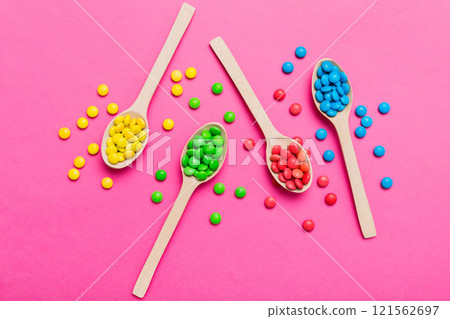 delicious colorful sweet candies on spoon on colored background . Confectionery decor top view with copy space delicious colorful sweet candies on spoon on colored background . Confectionery decor top view with copy space 121562697