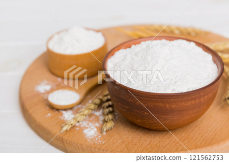 Flat lay of Wheat flour in wooden bowl with wheat spikelets on colored background. world wheat crisis 121562753