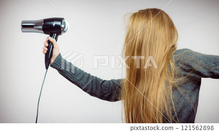 Woman holding hairdryer Woman holding hairdryer 121562898