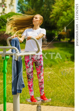 Female doing exercise in outdoor gym 121562925