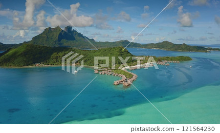 Breathtaking aerial perspective of turquoise coral reef lagoon, overwater bungalows, green forest hills, mount Otemanu forming a mesmerizing tropical oasis in Bora Bora, French Polynesia. Drone flight Breathtaking aerial perspective of turquoise coral reef lagoon, overwater bungalows, green forest hills, mount Otemanu forming a mesmerizing tropical oasis in Bora Bora, French Polynesia. Drone flight 121564230