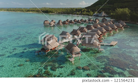 Stunning aerial view overwater bungalows in crystal clear turquoise lagoon of tropical island in French Polynesia. Exotic travel vacation getaway, romantic honeymoon, remote wild nature landscape 121564231